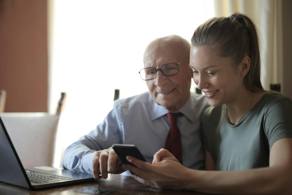 granddaughter helping grandfather with tech
