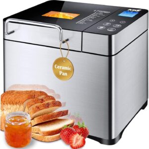 A silver bread maker with a digital display, labeled buttons, and a visible loaf inside. Sliced bread, strawberries, and a jar of jam are in front, and a tag reads Ceramic Pan.