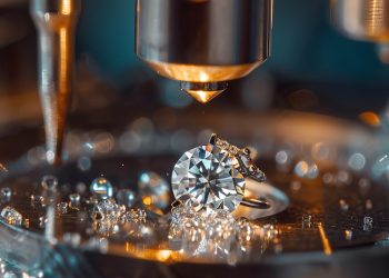 A close-up of a diamond ring under a microscope, surrounded by small water droplets on a reflective surface, highlighting the brilliance and precision of one of a kind jewelry designed by you.