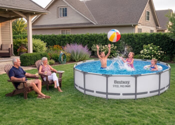 Two adults sit on lawn chairs while three children play with a beach ball in a round above-ground pool—the best backyard pool for family fun—in a well-kept, green backyard. Houses and bushes provide a pleasant backdrop to this lively summer scene.