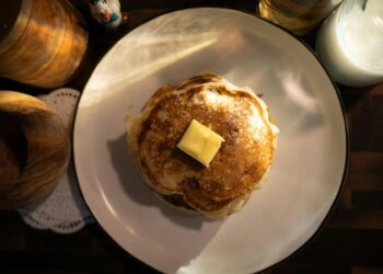 Stack of pancakes with butter on plate