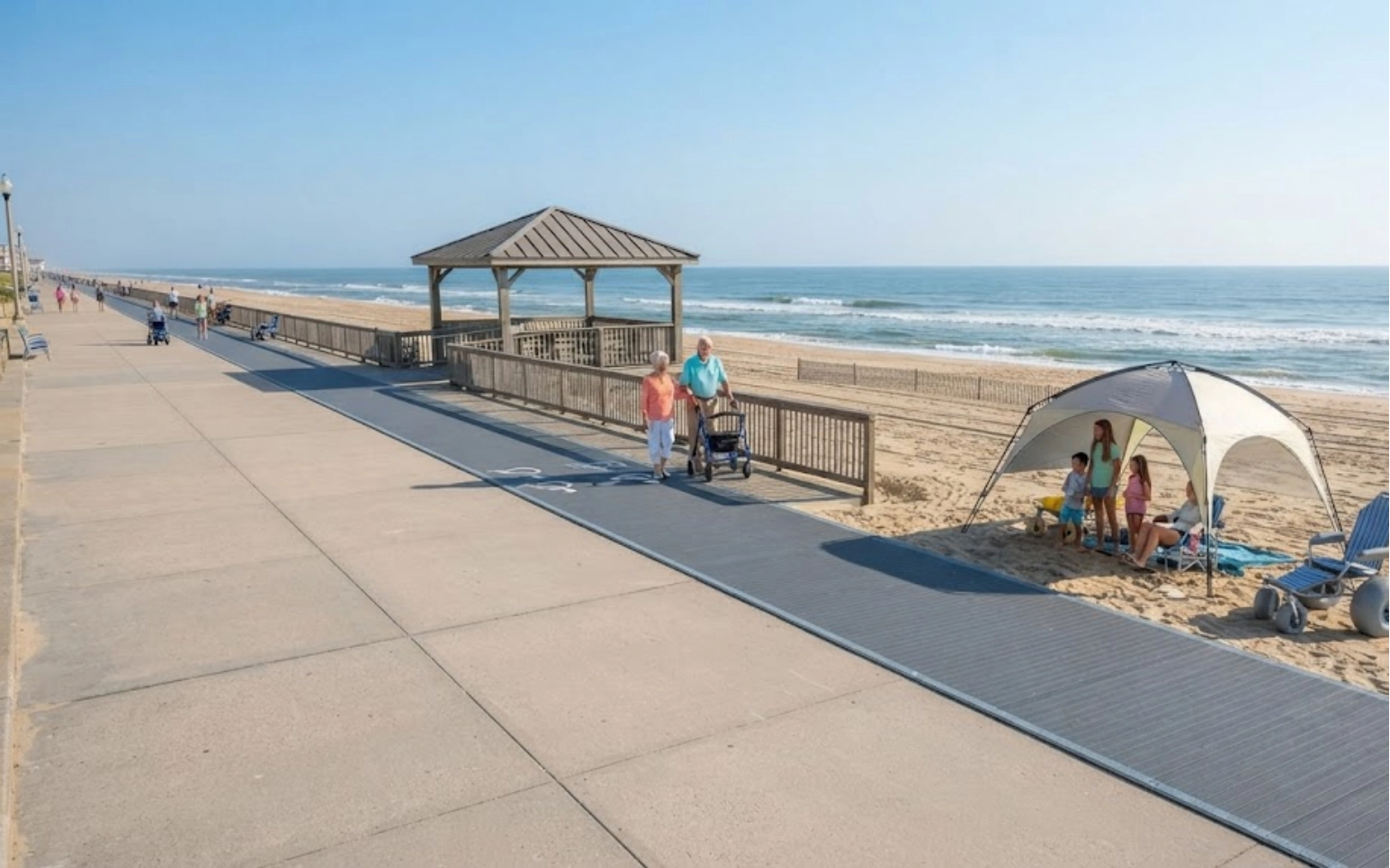 An elderly couple walks on a boardwalk beside the beach, while a family sits under a canopy on the sand. The ocean and a clear blue sky are in the background.