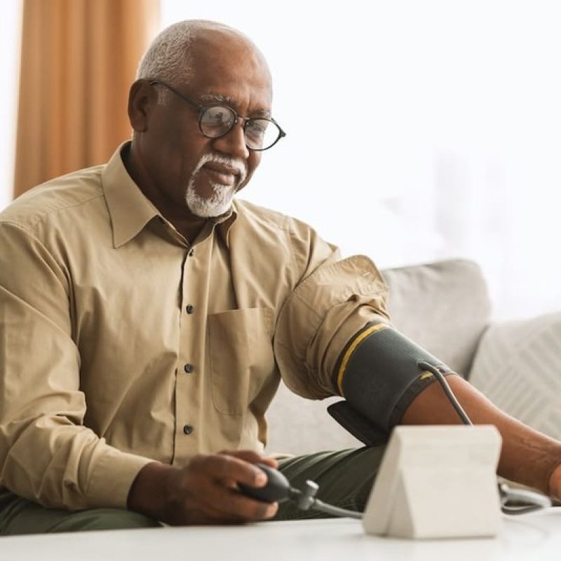 Older Adult Checking Blood Pressure at Home Senior man using a digital blood pressure cuff at home.